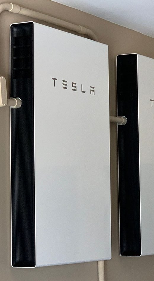 Two Tesla Powerwall batteries installed on an interior wall